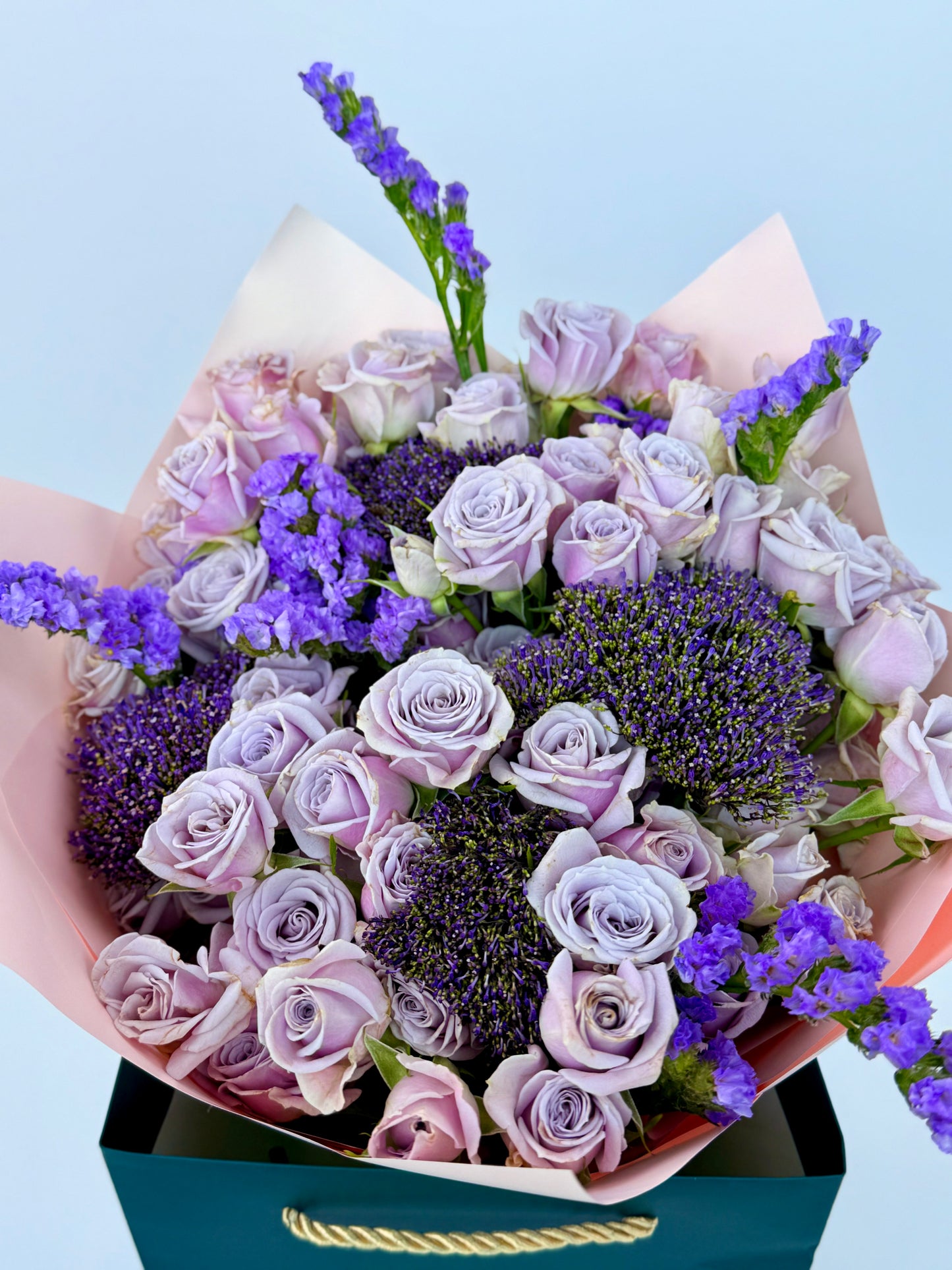 Lavender roses and deep purple blooms wrapped in pink paper – luxury flower bouquet in Dubai
