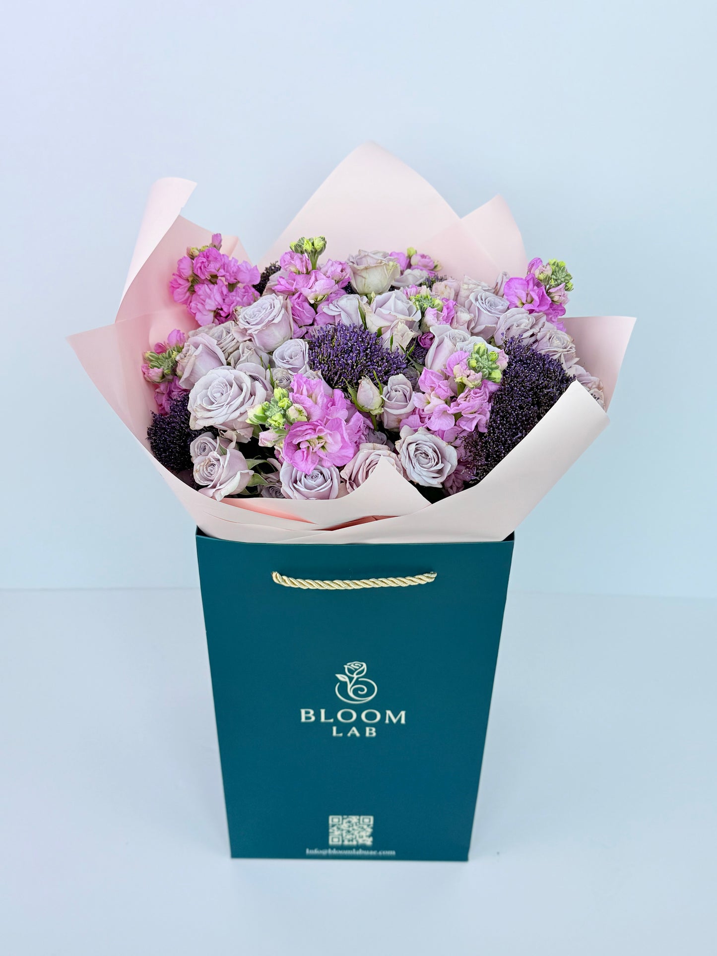 Bouquet of flowers in a 'Bloom Lab' box on a light blue background