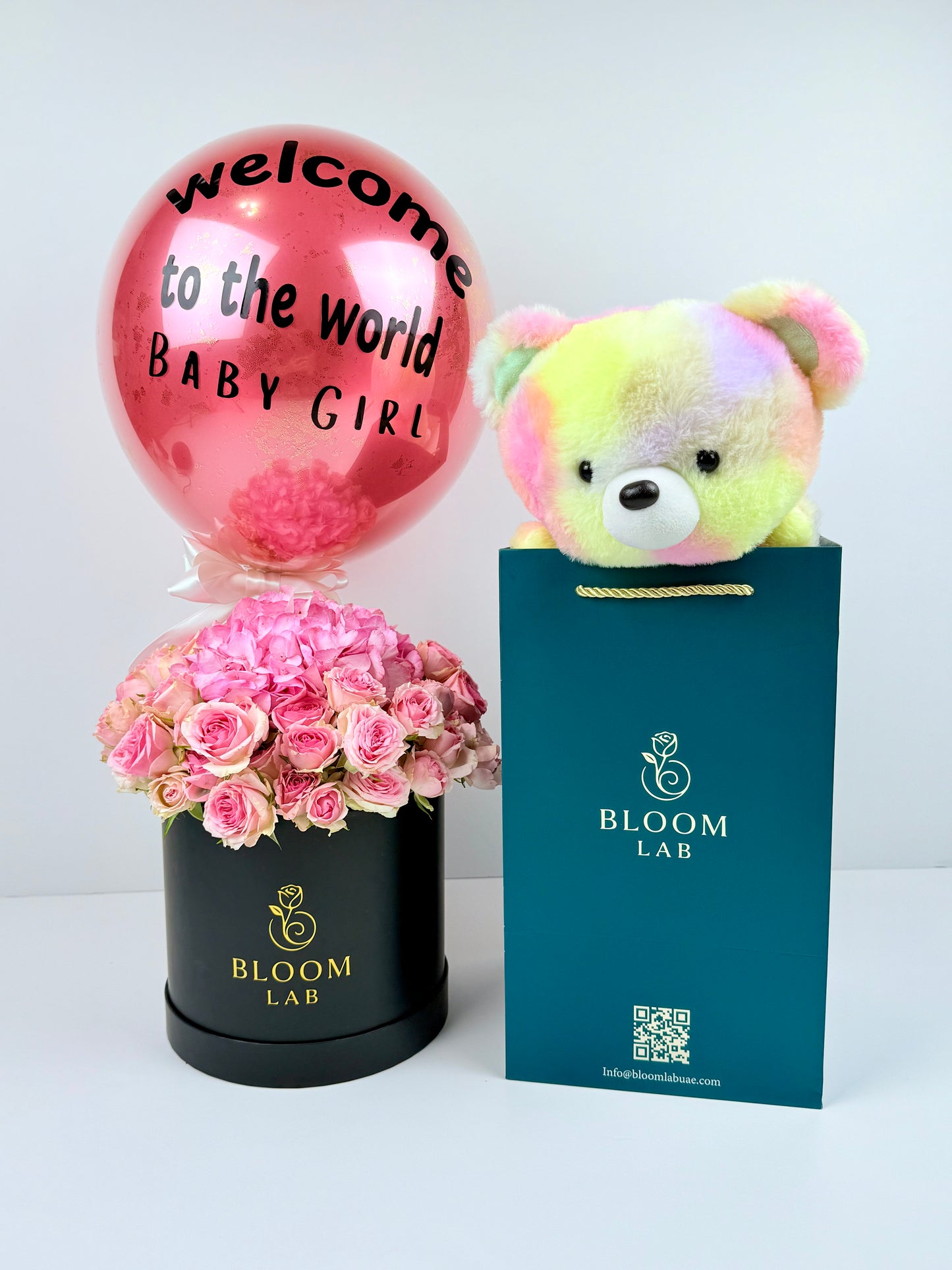 Pink roses in a black box with welcome baby girl balloon and rainbow teddy – newborn flowers Dubai