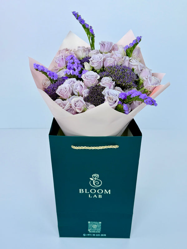 Lavender roses and deep purple blooms wrapped in pink paper – Flowers in UAE

