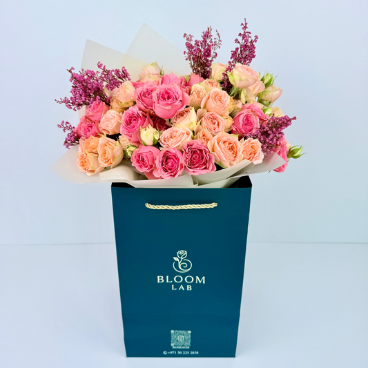 Peach and pink spray rose bouquet with purple statice – fresh online flowers in Dubai with free same-day delivery by Bloom Lab UAE.