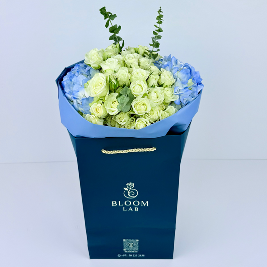 White roses and blue hydrangeas bouquet – fresh online flowers in Dubai with free same-day delivery by Bloom Lab UAE.